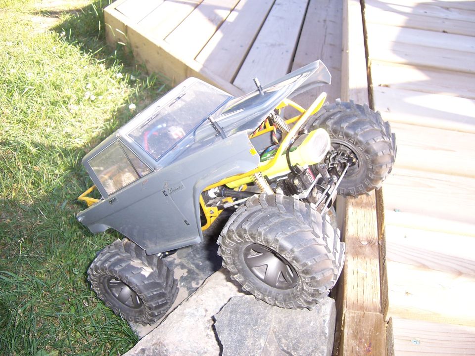 RC rock crawler truck with large tires on a wooden ramp