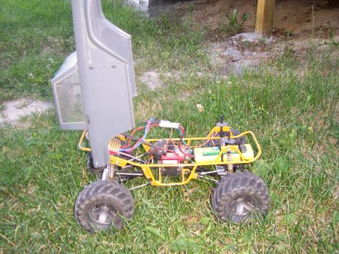 1996 Ford Bronco - This remote control monster truck features a yellow chassis with exposed wiring and electronics, and its body is propped open.