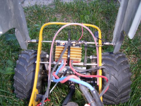 1996 Ford Bronco - The rear view of a remote control car chassis shows its internal components, including a gold motor and yellow roll cage.