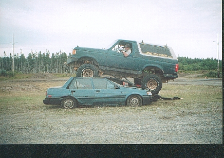 1989 Ford Bronco - A lifted 1989 Ford Bronco is shown crushing a blue sedan in a car crushing event.