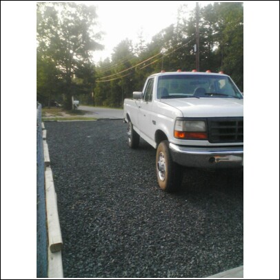 2004 Jeep Wrangler - This 1992 Ford F-250 pickup truck is parked on a gravel lot with trees in the background.
