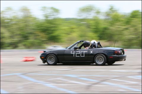 2001 Mercury Grand Marquis - A black convertible sports car with racing numbers is seen on a track during an event.