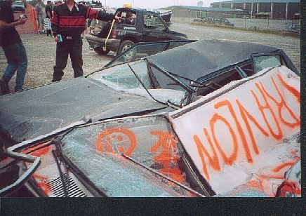 1989 Ford Bronco - Graffiti covers the windshield of a wrecked car at a demolition derby event.