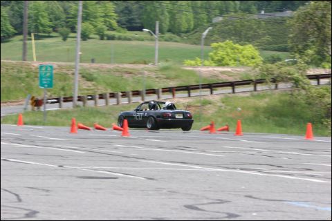 2001 Mercury Grand Marquis - A black convertible sports car navigates an autocross course marked by orange cones.