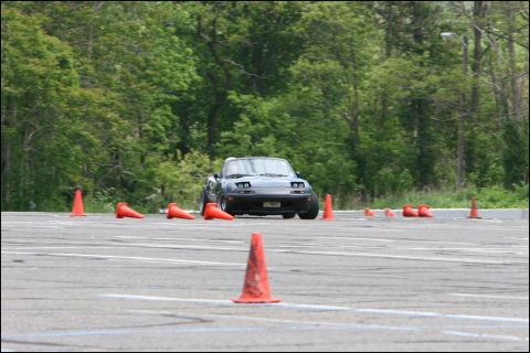 2001 Mercury Grand Marquis - A dark gray Mazda Miata navigates an autocross course marked by orange cones.