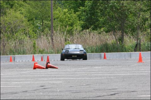 2001 Mercury Grand Marquis - A black Mazda Miata MX-5 navigates an autocross course marked by orange cones.
