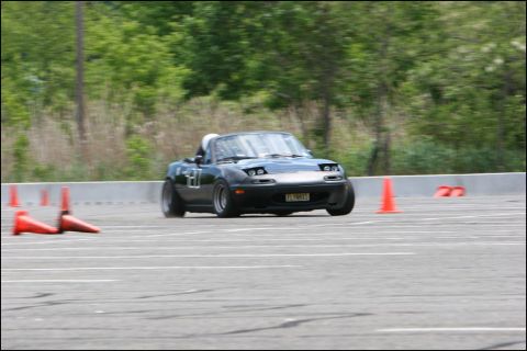 2001 Mercury Grand Marquis - Mazda Miata MX-5 navigates an autocross course on a sunny day.
