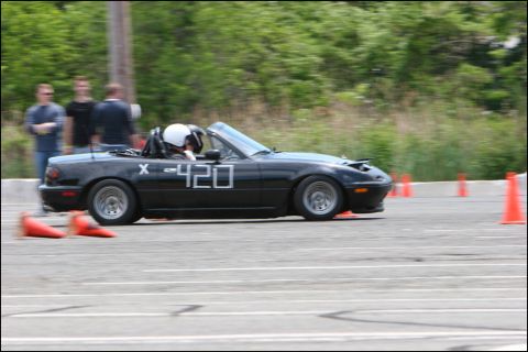2001 Mercury Grand Marquis - A black convertible sports car navigates an autocross course, marked with racing numbers.