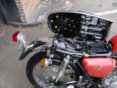 1985 Ford Crown Victoria LTD - The rear section of a motorcycle is shown with the seat cover open, revealing internal components.