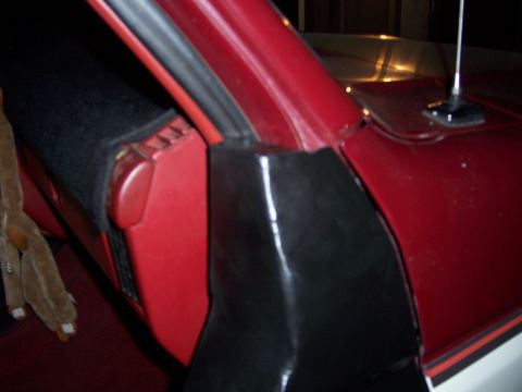 1991 Ford Bronco - Detail shot of the interior of a red vehicle, focusing on the door jamb and dashboard trim.