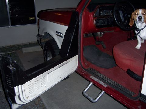 1991 Ford Bronco - Interior view of a 1991 Ford Bronco, showing the driver's seat and open door with a beagle.