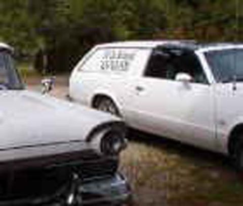 1971 Ford Ranchero - Two white vehicles are parked outdoors. Text is visible on the side of the rear vehicle.