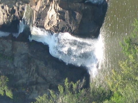 1985 Ford LTD Crown Victoria - A scenic view of a waterfall flowing over rocky terrain, with lush greenery surrounding the water.