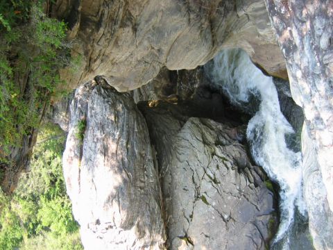 1985 Ford LTD Crown Victoria - A waterfall flows through a rocky gorge, surrounded by trees.