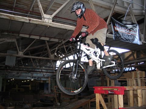 1997 Ford Probe - A mountain biker performs a jump inside an indoor park, with a Mongoose banner visible in the background.