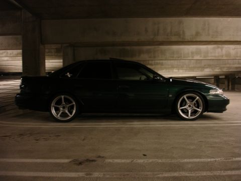 1993 Ford Taurus - A dark green 1993 Ford Taurus is seen from the side in a parking garage.