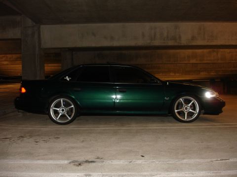 1993 Ford Taurus - Side profile of a green 1993 Ford Taurus sedan parked indoors.