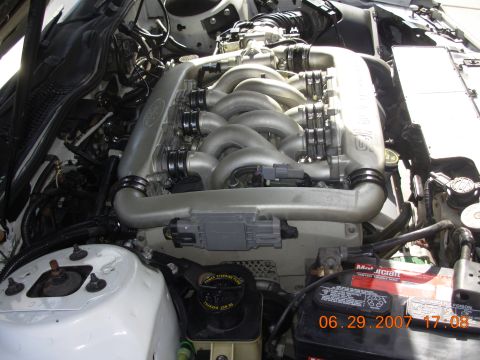 1995 Ford Taurus - Close-up view of a car's engine compartment, showing the intake manifold and other engine components.