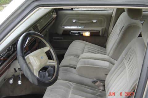 1989 Ford Crown Victoria LTD - The interior of this Ford sedan features plush velour seating and a classic dashboard layout.
