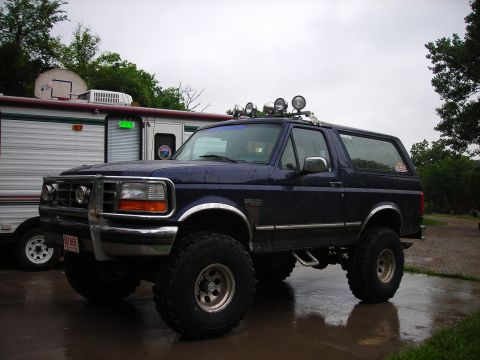 1994 Ford Bronco - This 1994 Ford Bronco features a custom front bumper with auxiliary lights and a roof-mounted light bar, complemented by oversized off-road…