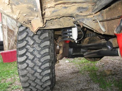 1988 Ford Bronco - Close-up of a vehicle's undercarriage, focusing on the suspension and a large off-road tire. The registry claims it is a 1988 Ford Bronco,…