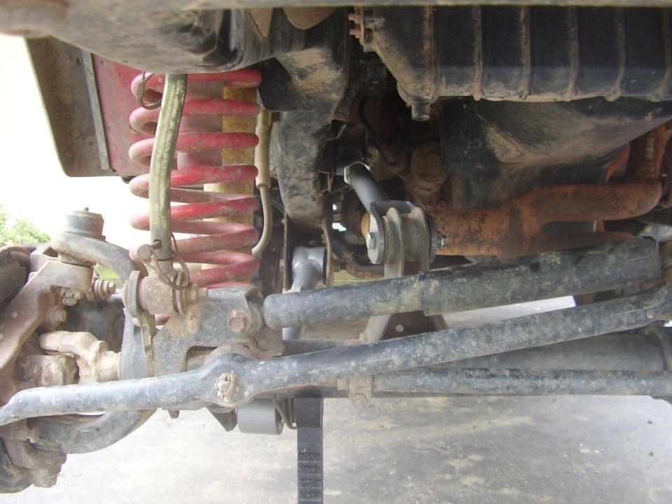 Close-up of Jeep suspension with red coil springs and various metal linkages