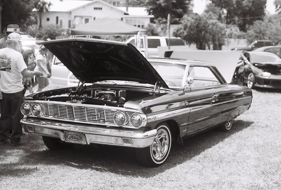 1964 Ford Galaxie 500 with hood open, front 3/4 view, chrome grille, and custom wheels