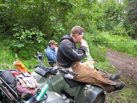 2000 Ford E350 - Two men take a break to eat on their ATVs in a wooded area with a dirt path.