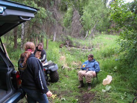 2000 Ford E350 - A group of people are taking a break in a wooded area with an ATV nearby.