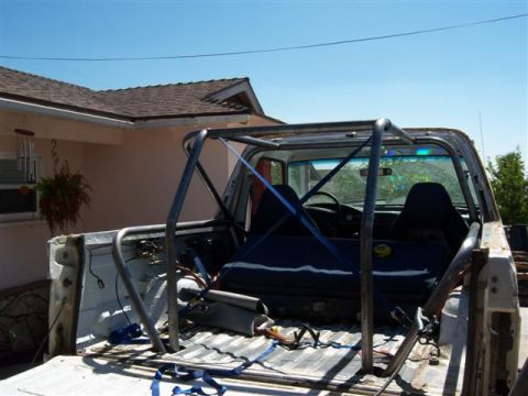 1995 Ford Bronco - Custom rollcage installed in the bed of a truck, with interior and seats visible.