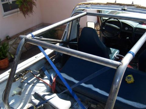 1995 Ford Bronco - Custom roll cage installed inside a truck's interior, with seats and dashboard visible.