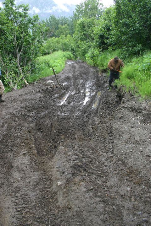 2003 Jeep TJ - A person works on a very muddy and difficult off-road trail.