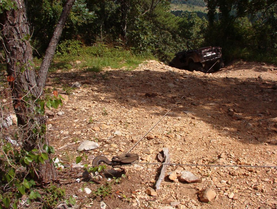 Trash on the trail!  Our entrance to the Rubicon was blocked by this abandoned Heep, whose LHF steering knuckle was no longer attached to the axle housing.  We did him the favor of pulling it back up to level ground.  Unfortunately, his LHR tire came off the rim in the process, and the LHF tie rod end separated.  Sorry, but I doubt he could have gotten it out of there in any better condition.