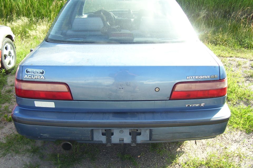 Rear view of a blue Acura Integra GS Type-R. A portion of another car is visible on the left