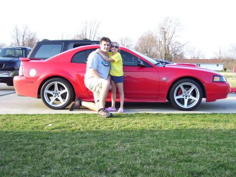 2004 Ford Mustang - Man and child pose next to a red 2004 Ford Mustang.