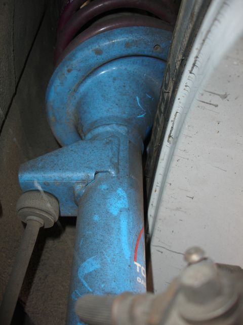 1993 Ford Taurus - Close-up of a blue shock absorber with visible lettering and a purple spring.