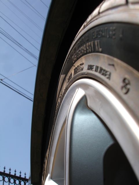 1993 Ford Taurus - A close-up view of a vehicle's tire and wheel assembly, with text visible on the tire sidewall.