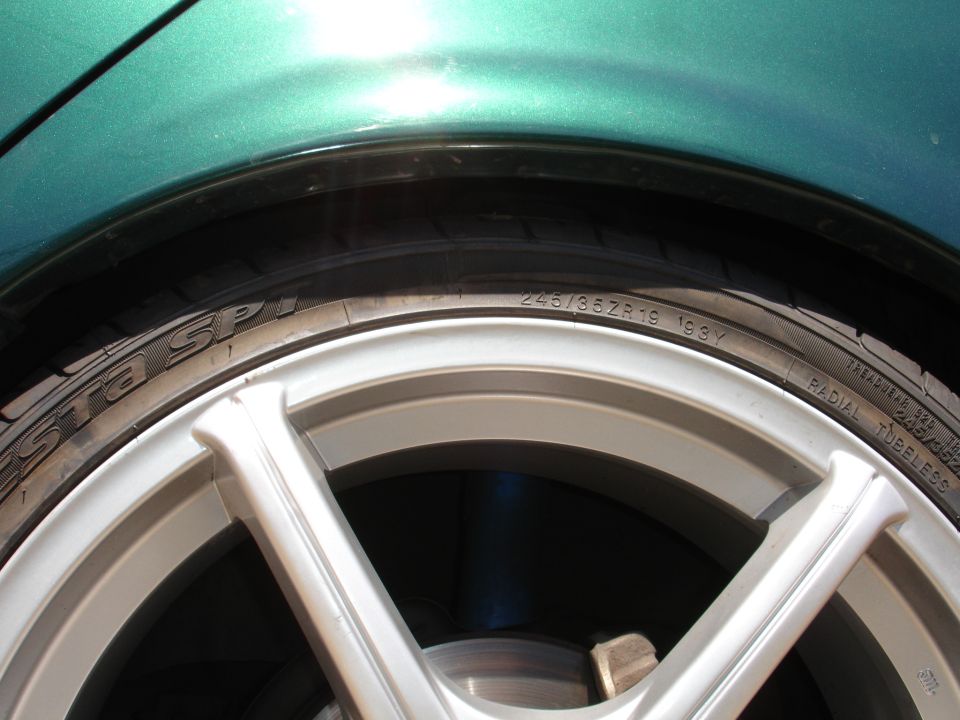 Close-up of a 245/35ZR19 tire with '1993' visible on the sidewall, mounted on a silver multi-spoke wheel