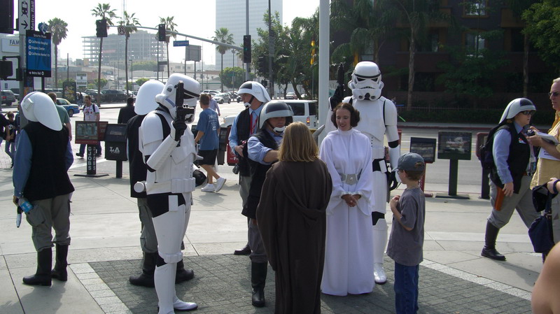 People in Star Wars costumes, including Stormtroopers and Princess Leia, gathered outdoors