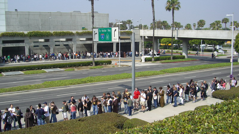 White SUV parked near a freeway entrance with people in line