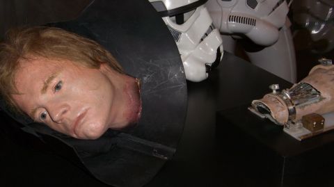 1990 Ford Probe - A prop severed head and a stormtrooper helmet are displayed, with a partial robotic arm in the background.
