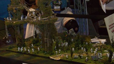 1990 Ford Probe - A detailed diorama displays a miniature battle scene with numerous figures and foliage.