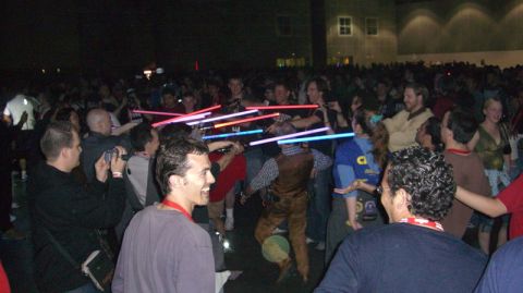 1990 Ford Probe - A large group of people are gathered, many holding illuminated toy lightsabers.