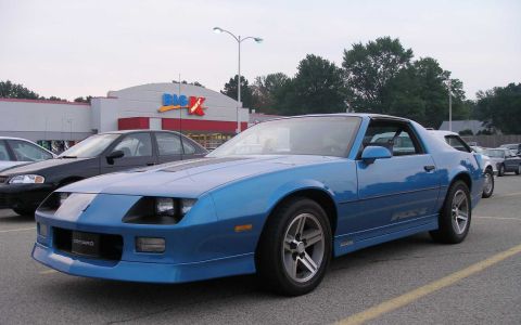1998 Ford Crown Victoria - A blue Chevrolet Camaro IROC-Z is parked in a lot in front of a Big Kmart store.