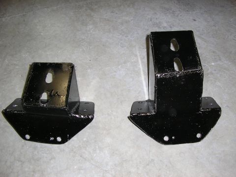 1979 Ford F-350 - Two black metal brackets are displayed on a concrete floor, likely for automotive use.