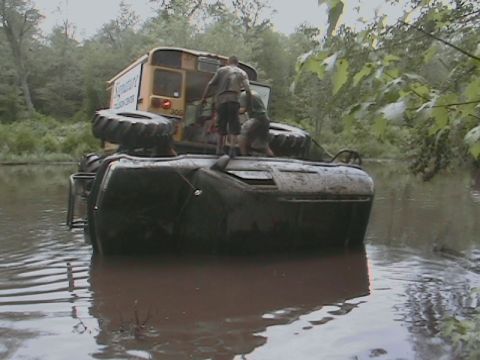1976 Chevrolet Blazer - An off-road vehicle is stuck in the water, with another vehicle on top of it.