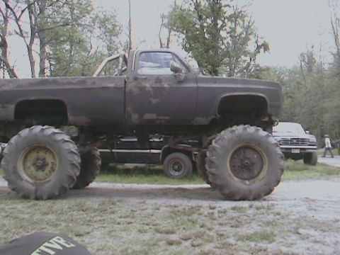 1976 Chevrolet Blazer - A heavily modified truck with oversized tires and a lifted chassis sits in an outdoor setting.