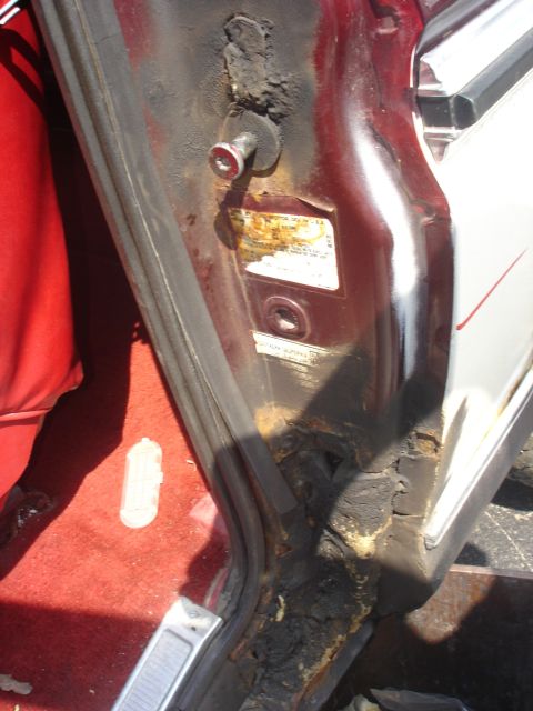 1979 Ford Bronco - Close-up of a rusted door jamb with a visible sticker.