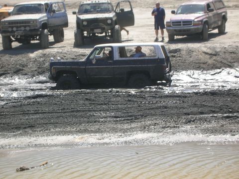 1985 Ford Bronco - This SUV appears to be a 1973 model, not a 1985 Ford Bronco, as it navigates through a muddy terrain.