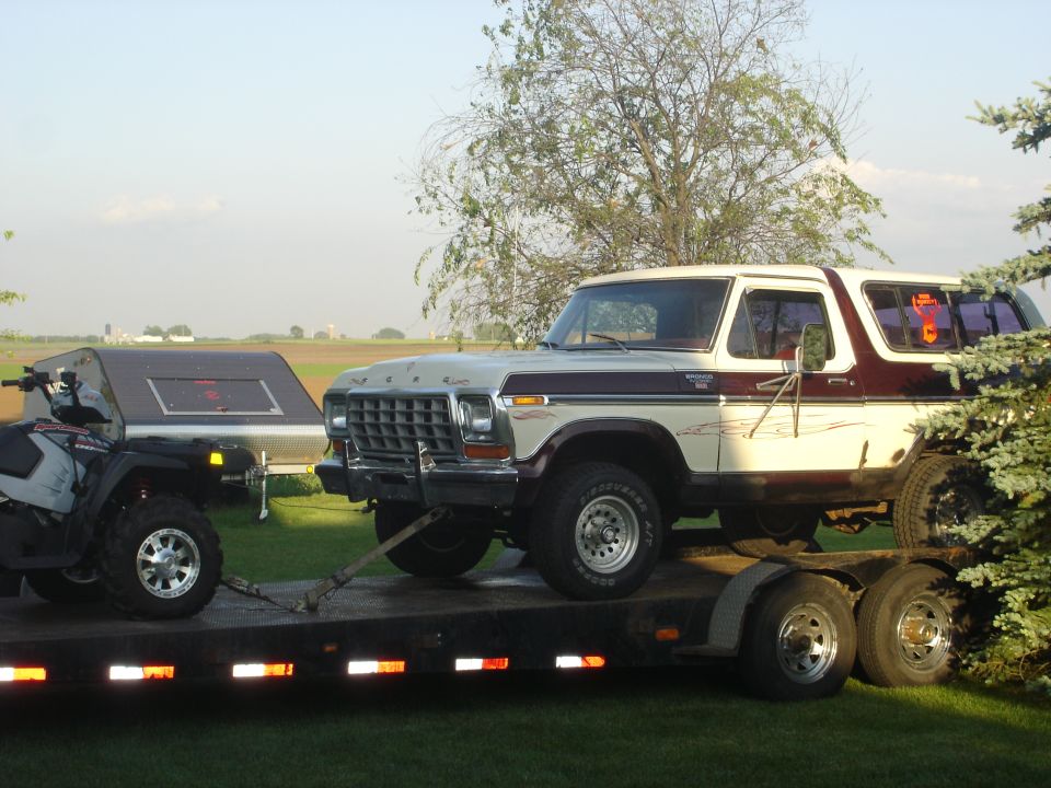 1979 Ford Bronco on a flatbed trailer, with an ATV in front of it